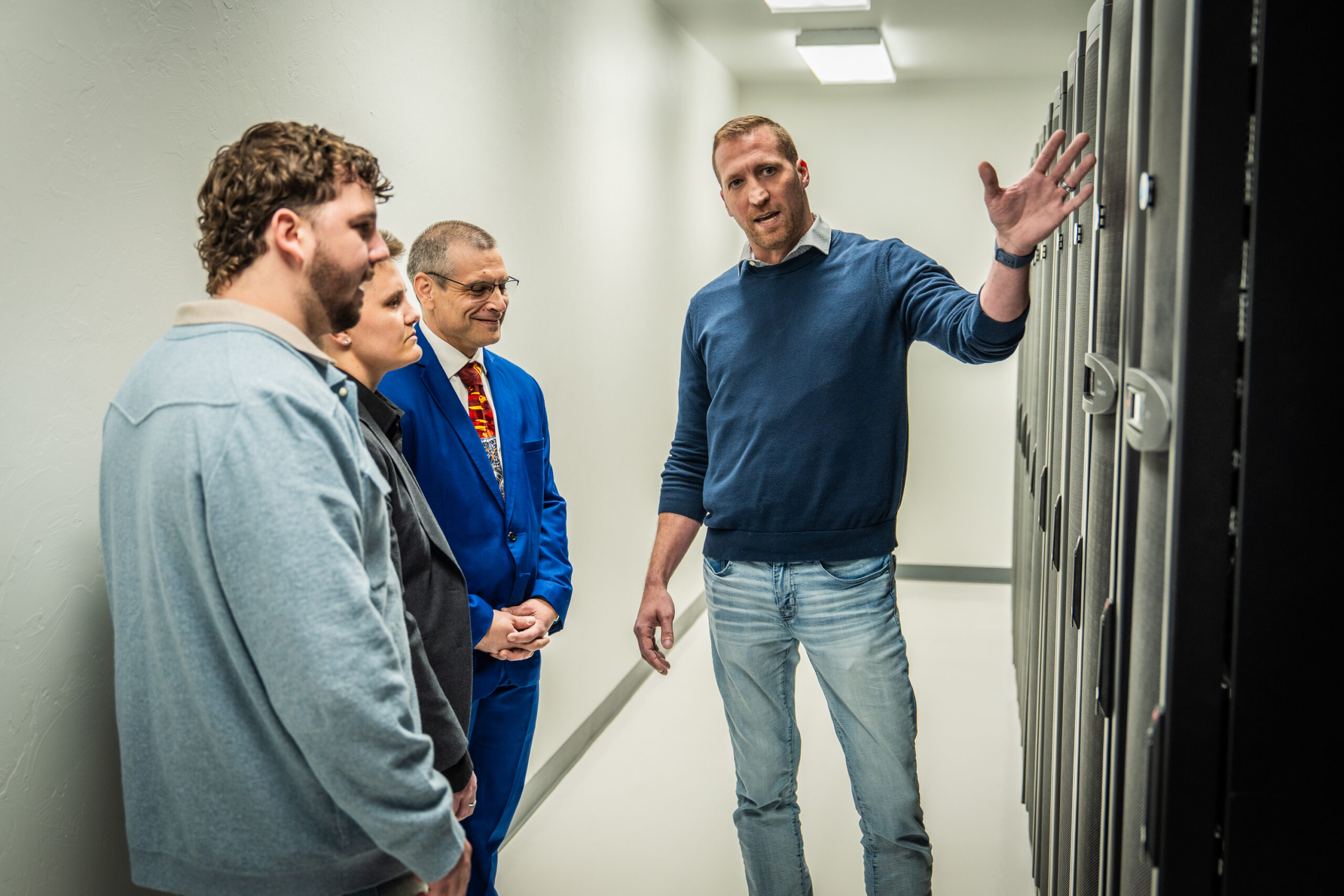 Man explaining to a group in front of a server.