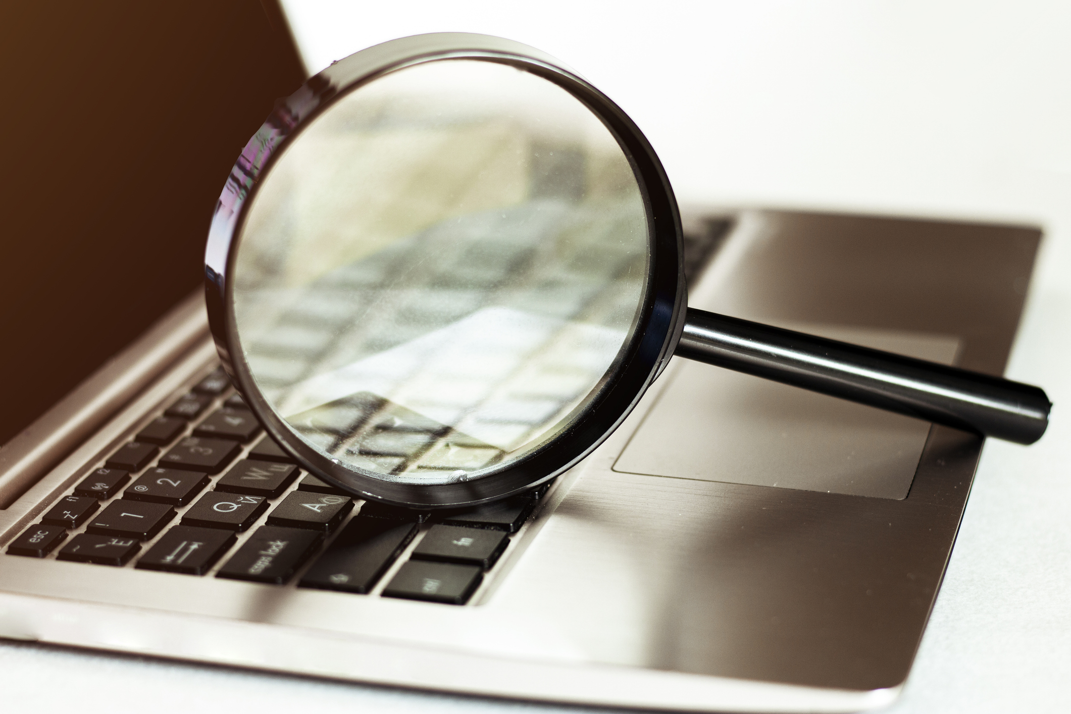 Laptop with magnifying glass for Cyber Risk Assessment
