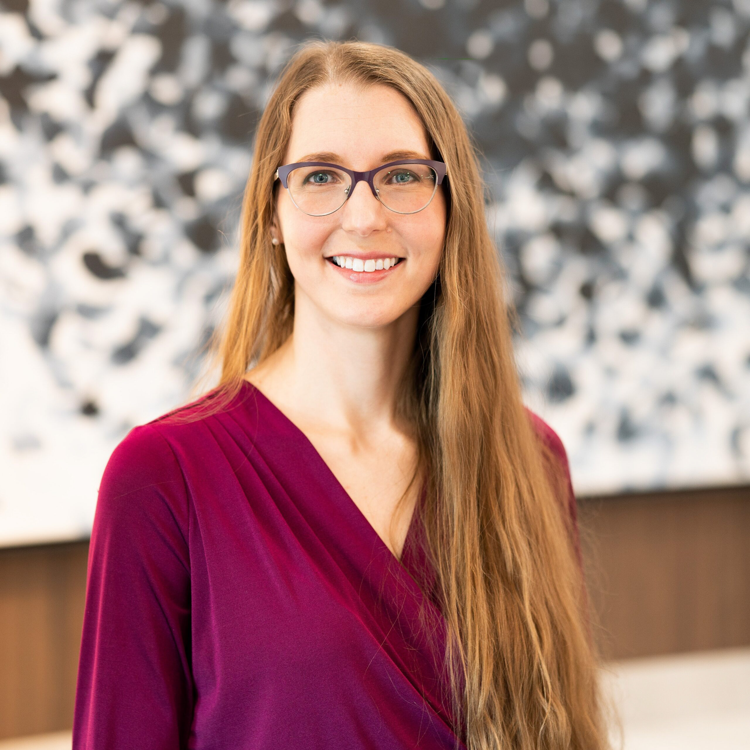Navanta employee - Smiling woman in front of bokeh background.